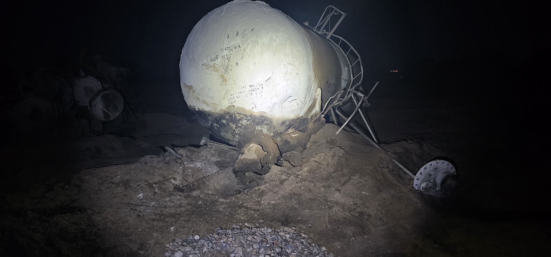 Damaged tank car resting in disturbed ground at the Green Valley derailment recovery site