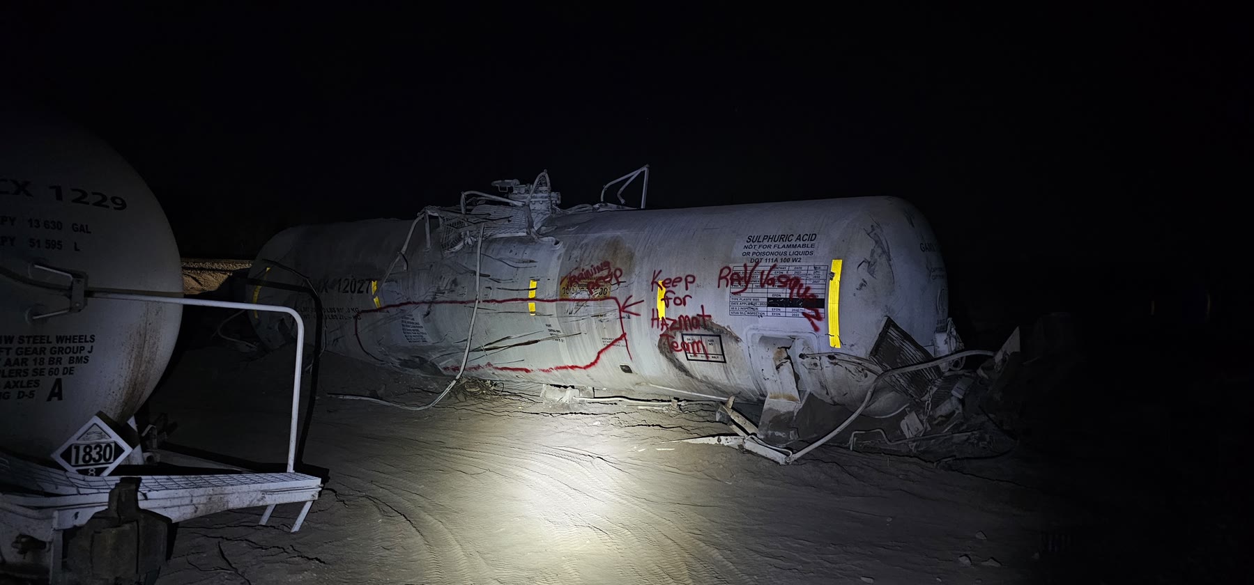 Damaged sulfuric-acid tank car marked for the hazardous-material team at the Green Valley derailment site