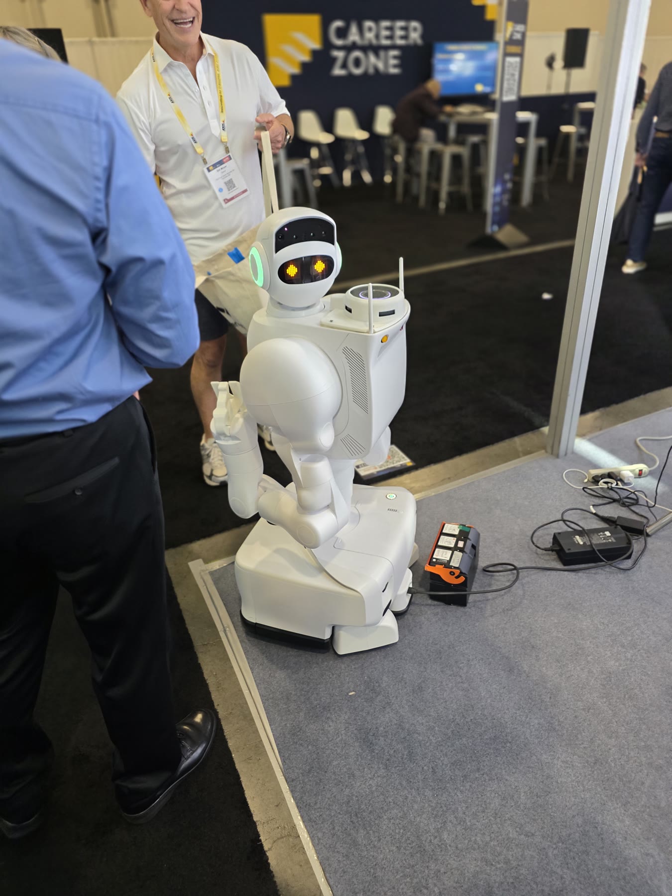 Compact white service robot interacting with attendees near the ISC West Career Zone