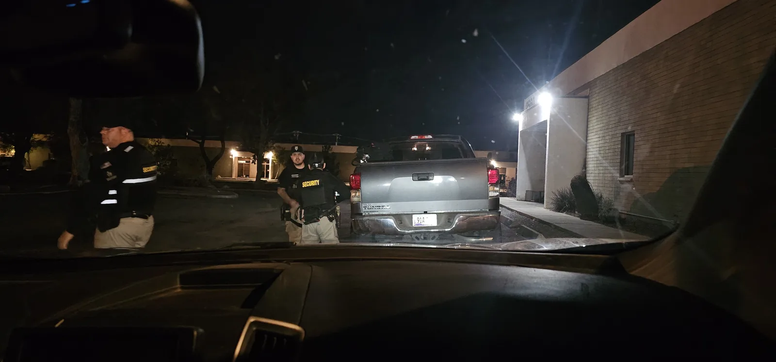 Privateer Security Forces officers working together near a patrol vehicle at night