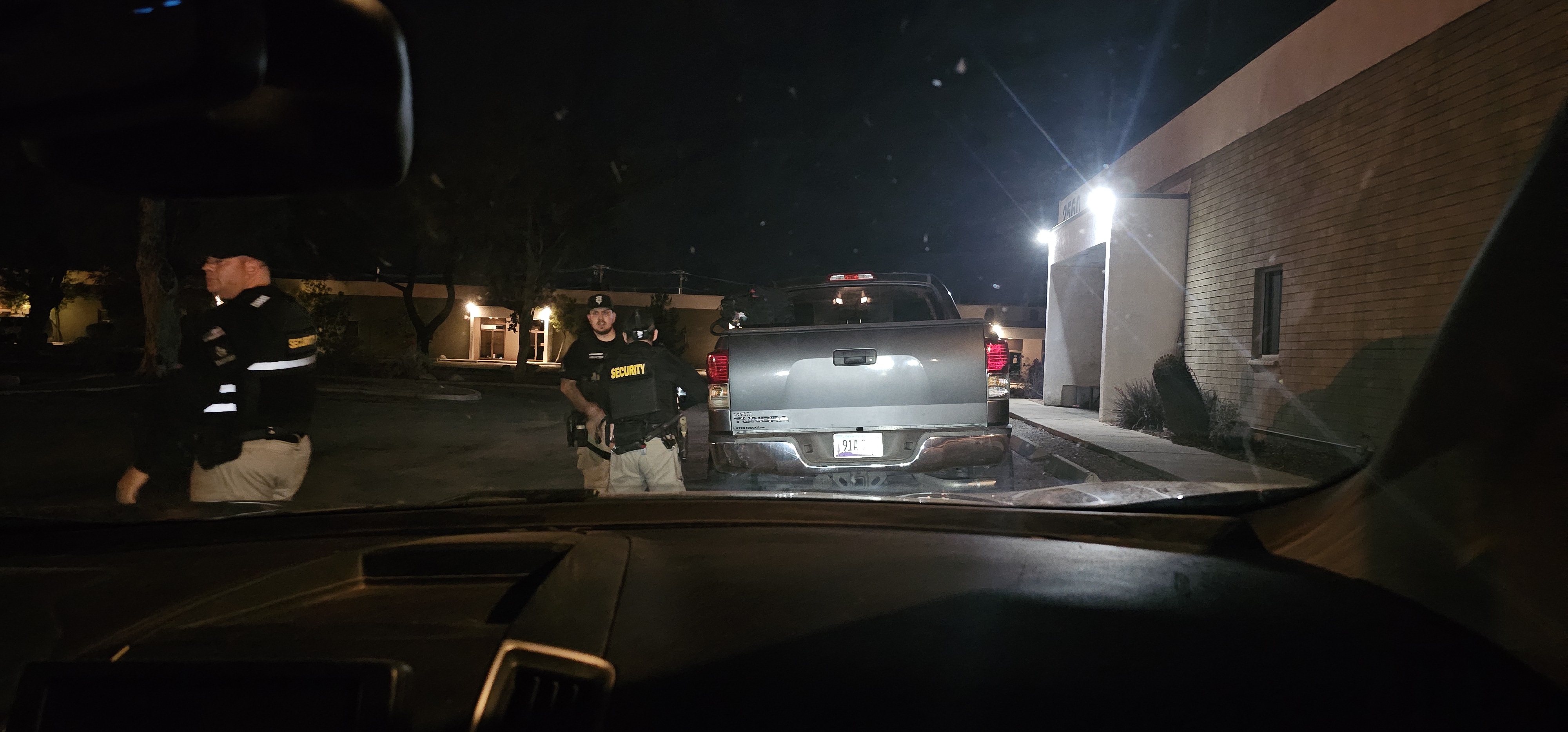 Privateer Security Forces officers working near a patrol vehicle at night
