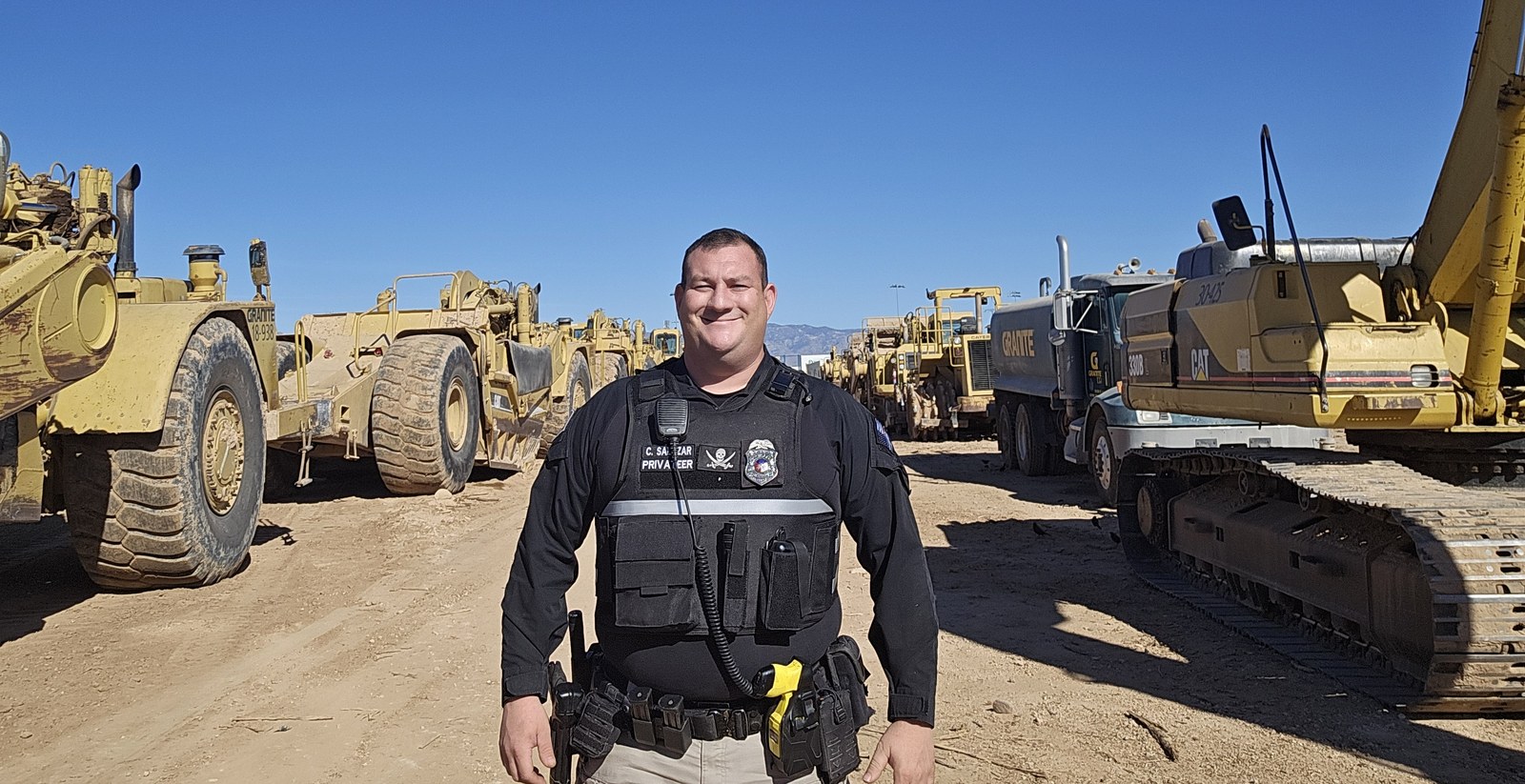 Privateer officer among heavy construction equipment in a separate company archive assignment